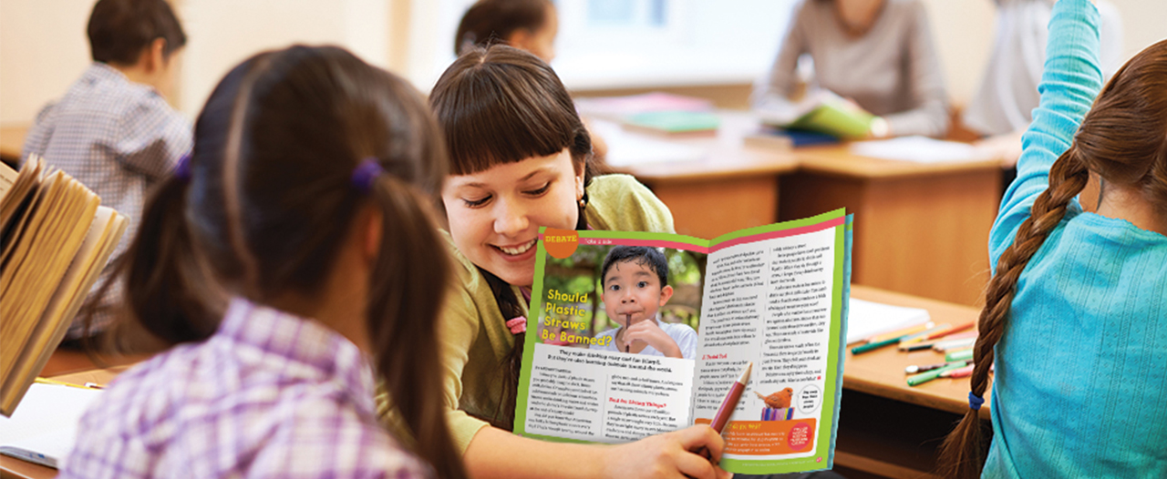 Student sharing magazine content with another student.
